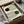 May include: Framed Bauhaus exhibition poster with geometric design featuring curved concentric lines, black and green circles on cream background, displayed in black frame inside cardboard shipping box with protective tissue paper wrapping