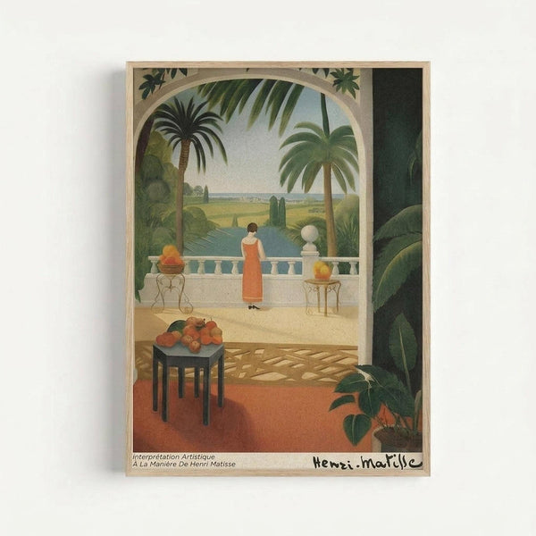 Framed vintage-style art print depicting a tropical terrace scene with a woman in an orange dress standing on a white balustrade overlooking palm trees and water. The composition includes a table with fruit in the foreground, ornate furniture, lush green foliage, and warm earth tones throughout. Text at bottom reads "Interprétation Artistique À La Manière De Henri Matisse" with an artist signature.