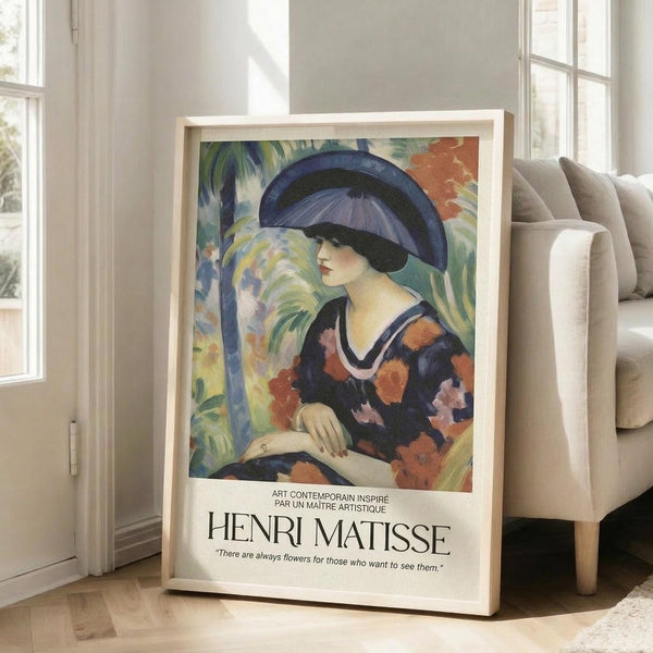 May include: Framed art print featuring a woman in a blue hat and floral dress in Matisse's colorful style, displayed against white wall next to beige sofa with natural lighting from nearby windows creating soft shadows on hardwood flooring.