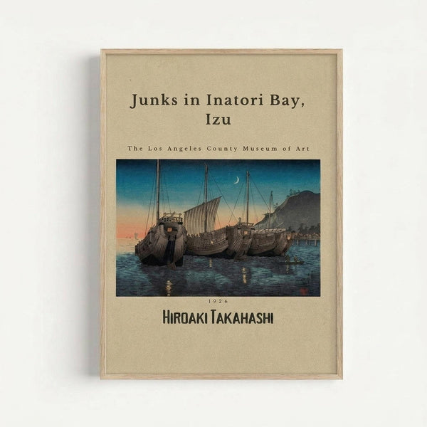Framed vintage Japanese woodblock print showing traditional sailing junks with tall masts anchored in a bay at twilight. The artwork features deep blue water reflecting golden lights from the wooden boats, with mountains silhouetted against an orange and blue gradient sky. A crescent moon appears in the upper portion. The print is matted in cream with text identifying it as from The Los Angeles County Museum of Art, dated 1926, by Hiroaki Takahashi. The piece is displayed in a light wood frame a
