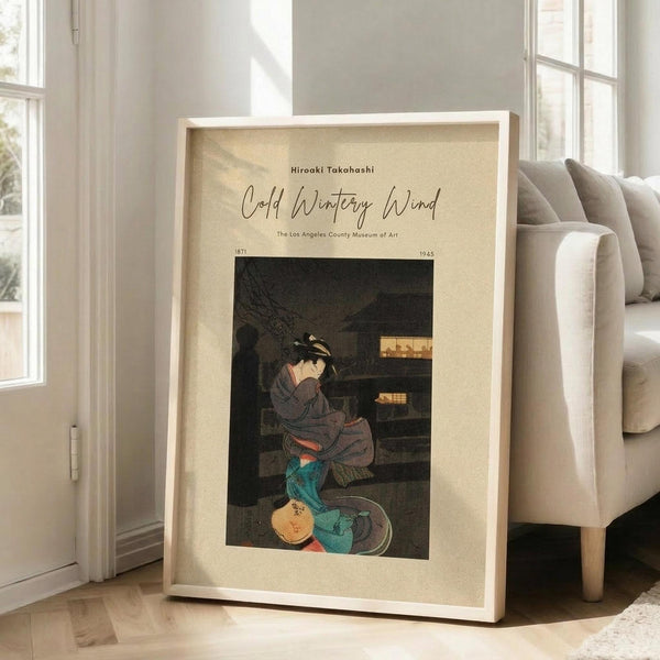 May include: Framed art print featuring a Japanese woman in traditional dress sitting by wooden shelves, displayed on wooden floor next to beige upholstered chair in bright room with white walls and large windows. Print has cream mat border with black text and shows figure in gray kimono with teal fabric, rendered in vintage ukiyo-e woodblock style with muted earth tones.