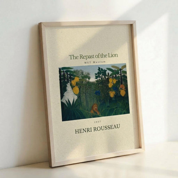 May include: Framed museum poster print leaning against white wall corner. Features Henri Rousseau's jungle painting with lush green foliage, yellow fruits, white statue figure, and small lion in dense tropical vegetation. Cream colored poster with elegant typography in natural wood frame, soft natural lighting creating gentle shadows.