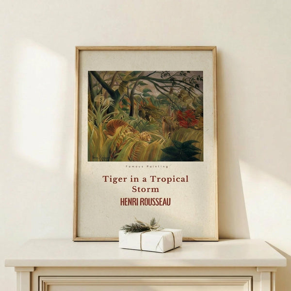 May include: Framed vintage-style art print featuring Henri Rousseau's tropical jungle scene with a tiger among dense green foliage and ferns. The poster has cream-colored text below the artwork identifying the painting and artist. Natural wood frame sits on a light wooden surface next to a small white wrapped gift with twine and greenery against a neutral beige wall.