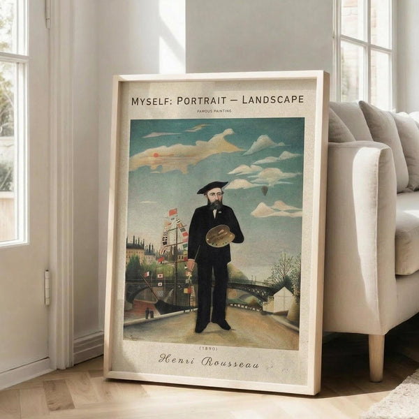 May include: Large framed vintage-style poster print leaning against white wall next to beige sofa. The artwork shows a mustachioed man in black suit and beret holding an artist's palette, standing in a whimsical landscape with buildings, bridge, and cloudy sky. The print has cream matting with text at top and bottom, housed in light wood frame on hardwood floor.