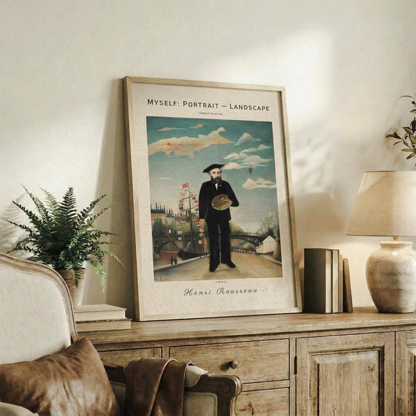 May include: Framed art print featuring a man in black suit holding a hat, standing in a landscape with buildings and cloudy sky. Displayed on rustic wooden sideboard with fern plant, ceramic vase, table lamp, and books in neutral-toned living room setting.