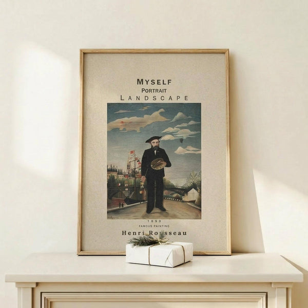 May include: Framed art print featuring a self-portrait of a bearded man in dark clothing holding a painter's palette, standing in an urban landscape with buildings and cloudy sky. The vintage-style poster has cream matting in a thin wooden frame, displayed on a light wood surface alongside a small white wrapped gift with twine and greenery.