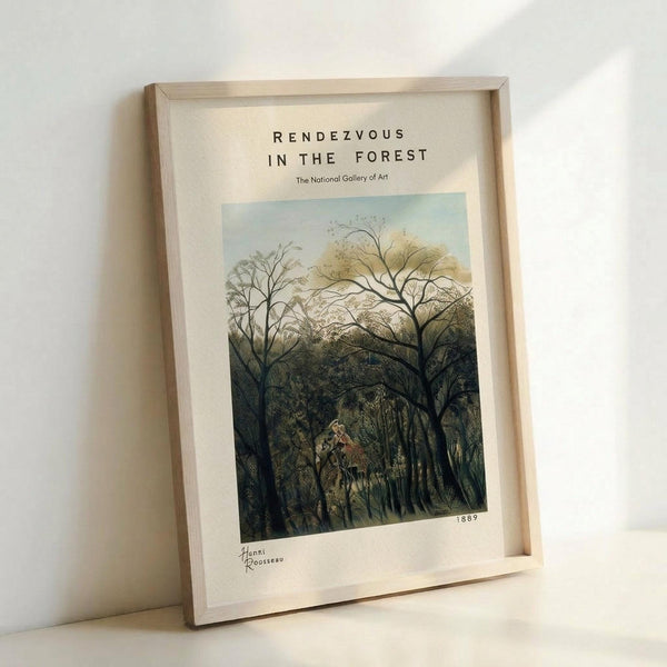 May include: Framed art print in light wood frame showing Henri Rousseau's jungle forest painting with bare trees, lush green foliage, and small figures in a clearing. The poster features museum-style white matting with "RENDEZVOUS IN THE FOREST" text, "The National Gallery of Art" attribution, and "1889" date. Frame leans against white wall on light surface with soft natural lighting.