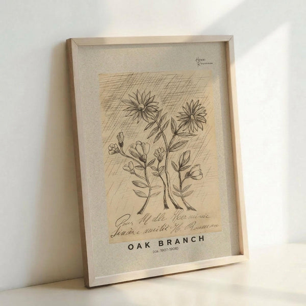 May include: Framed botanical illustration print leaning against white wall, featuring detailed pen and ink drawings of flowers and plants on aged paper background. Light wood frame contains artwork with crosshatched shading technique, handwritten text, and "OAK BRANCH" title at bottom. Natural lighting creates soft shadows on textured linen mat.