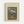 Framed vintage botanical poster showing a floral still life with pink and white flowers including roses and carnations in a clear glass vase. The illustration features muted green background tones with orange table surface. Text reads "Flowers in a Vase vintage illustration" at top and "HENRI ROUSSEAU" at bottom with "1910" and "1909" dates. Light wood frame with cream matting against white wall.