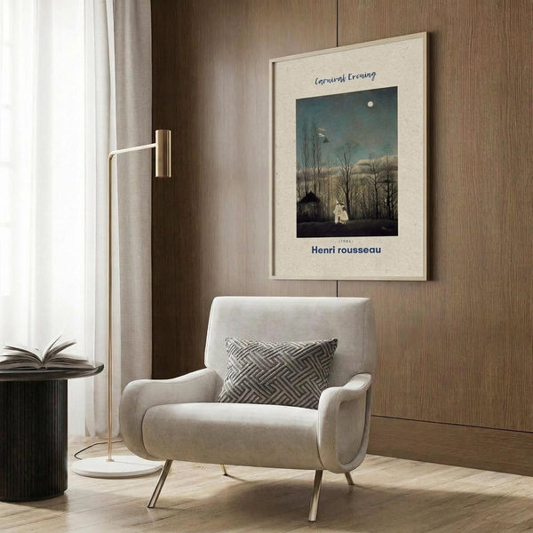 May include: Framed art print of a moonlit evening landscape with bare trees and small figures displayed on wood-paneled wall above beige upholstered armchair with geometric patterned pillow. Modern brass floor lamp and dark round side table with open book complete the neutral-toned reading corner setup.