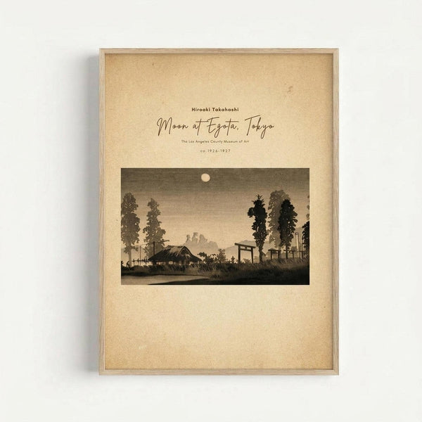 Framed vintage Japanese woodblock print showing a moonlit evening landscape with traditional buildings, tall trees, and silhouetted figures under a full moon. The artwork features muted earth tones and sepia colors on aged paper background, displayed in a simple light wood frame against a white wall.