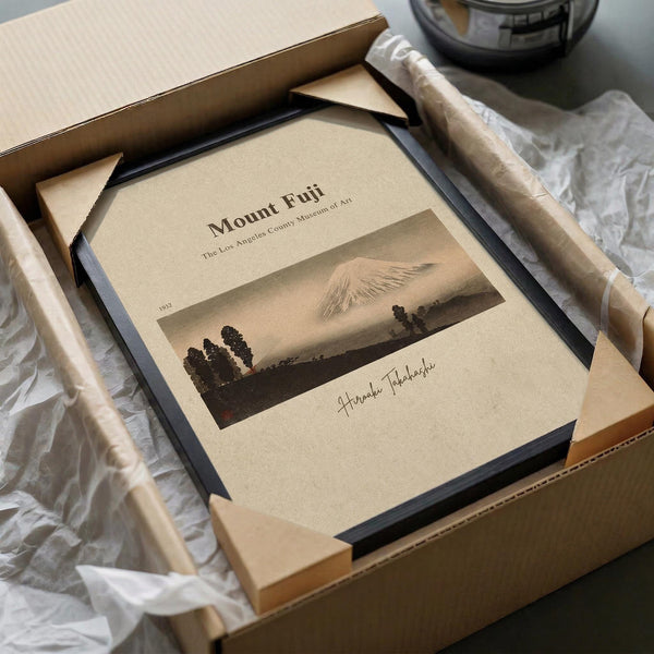 a framed print of Mount Fuji, a famous landmark in Japan, placed in a cardboard box.
