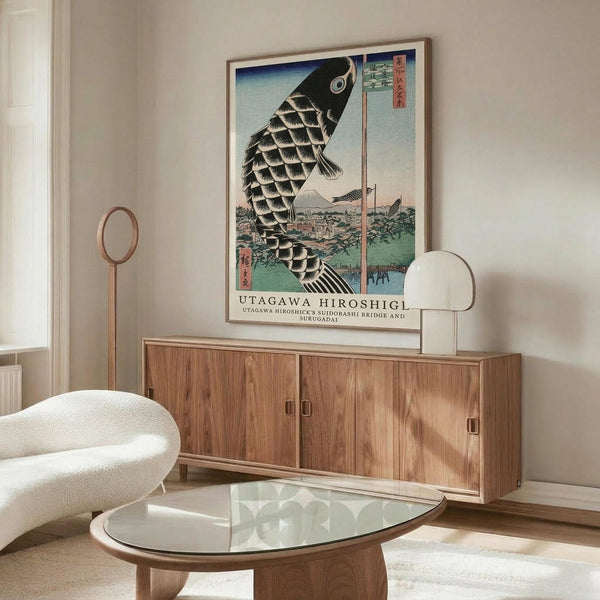May include: Japanese woodblock print poster featuring large black koi fish with detailed scales swimming above landscape with bridge and Mount Fuji, displayed in thin wooden frame above mid-century modern walnut credenza in minimalist living room with white curved chair, glass oval coffee table, and wooden floor lamp
