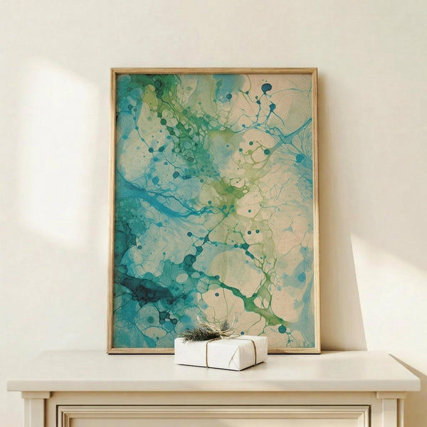 May include: Abstract watercolor artwork in wooden frame displayed on light wood console table against cream wall. Fluid organic shapes in turquoise, teal, sage green and cream tones with connected dots and flowing lines throughout. Small wrapped gift with natural sprig placed in front of vertical rectangular frame.