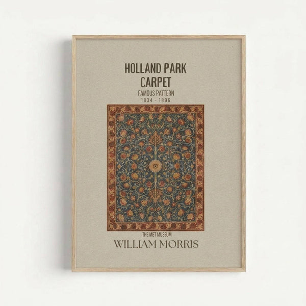 Framed poster displaying a vintage William Morris carpet design from The Met Museum. Features an ornate floral pattern in blues, oranges, and golds with decorative border on cream background. Light wood frame mounted on white wall. Text reads "Holland Park Carpet Famous Pattern 1834-1896" and "William Morris" at bottom.