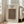 May include: Framed poster featuring an ornate vintage carpet design with intricate floral patterns in deep blues, oranges, and golds on cream background. Light wooden frame leans against white wall next to beige upholstered chair in bright, minimalist room with hardwood floors and large windows.