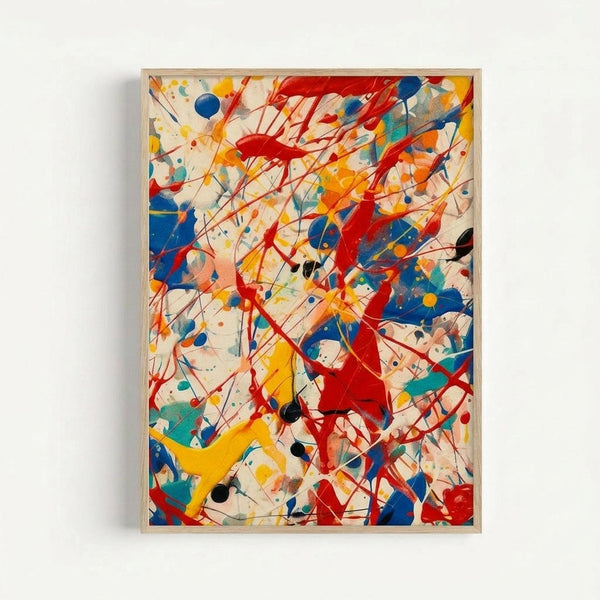 Abstract expressionist artwork featuring vibrant splashes and drips of red, blue, yellow, and black paint on a cream background. Dynamic lines and splatters create energetic movement across the canvas. The piece is displayed in a light wood frame against a white wall, showcasing the bold, gestural brushstrokes and paint drips characteristic of mid-century modern abstract art.