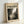 May include: Framed poster print leaning against white wall corner showing Jackson Pollock's abstract expressionist drip painting in black and white. Features chaotic splatters, drips, and gestural marks across canvas with "POLLOCK" in bold black letters above artwork and "CHAOS AND CREATIVITY 1912-1956" text. Light wood frame on cream colored poster with dramatic paint texture details visible.