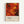 Framed abstract art poster featuring vibrant red, orange, and yellow paint splatters with black curved lines and circular shapes in Jackson Pollock's distinctive drip painting style. The artwork shows dynamic swirls and energetic brushstrokes against a fiery background. Below the image is white text reading "Jackson Pollock" with exhibition details "January 10-20, 1956, 8th Avenue, New York City" and "A Journey Through Chaos." The poster has a light wood frame and is displa