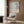 a modern living room with a white armchair, a floor lamp, and a framed poster on the wall.