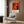 A modern living room with a white armchair, a floor lamp, and a framed abstract painting on the wall.