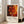 May include: Abstract artwork poster in white frame leaning against white wall next to beige sofa. Features vibrant red, orange, and yellow fluid paint with black marbled areas, circular bubble patterns, and flowing organic shapes. Exhibition-style design with "Jackson Pollock" text, dates, and "A Journey Through Chaos" subtitle below the colorful abstract composition.