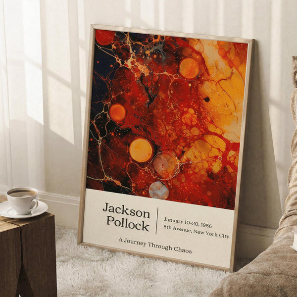May include: Framed art poster with abstract paint splatter design in vibrant reds, oranges, and yellows with dark accents and circular bubble patterns, displayed on white fluffy rug against white wall. Features exhibition-style text at bottom. Coffee cup on wooden block visible nearby, creating cozy room mockup scene.