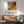 a poster of Jackson Pollock's artwork hanging on a wall in a room with a wooden cabinet below it.