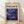 May include: Framed art poster featuring abstract swirling design in deep blues and purples with flowing organic shapes and scattered circular dots in yellow, white, and blue tones. The poster has "POLLOCK" in large black letters at top with "CHAOS AND CREATIVITY 1912-1956" subtitle on cream background. Natural wood frame sits against white wall on light wooden floor with soft shadows.