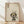 May include: Framed poster print featuring a cute black cat with large yellow eyes and rosy cheeks sitting next to green bamboo stalks, with Japanese characters at the top, displayed in a light wood frame against white walls on wooden flooring with natural sunlight shadows