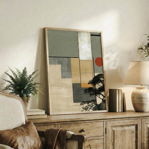 May include: Abstract geometric artwork with sage green, beige, and gray rectangular shapes plus orange circle, combined with silhouette of pine tree branches, displayed in light wood frame on rustic wooden sideboard alongside fern plant, books, and ceramic vase in neutral-toned living room