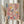 May include: Person holding framed abstract artwork featuring energetic paint splatters and brushstrokes in pink, blue, yellow, and cream tones with black linear elements, displayed in light wooden frame against soft neutral curtains with dried pampas grass visible to the left