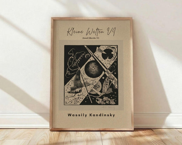 May include: Framed abstract art print featuring geometric black and white design with circular and angular shapes, displayed in light wood frame against white textured wall on wooden floor with natural lighting and shadows