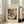 May include: Framed abstract art print leaning against white wall next to beige sofa in bright living room. The vintage-style poster features Wassily Kandinsky's colorful abstract composition with geometric shapes, lines, and vibrant colors including red, blue, yellow, and black on cream background. Natural light streams through tall windows onto hardwood floors.