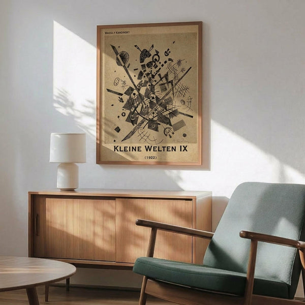 May include: Abstract geometric artwork by Wassily Kandinsky displayed in wooden frame on white wall above mid-century modern credenza. Print features black line drawings and shapes on beige background. Scene shows mint green upholstered chair with wooden arms, white ceramic table lamp, and natural lighting creating shadows across the minimalist interior setting.