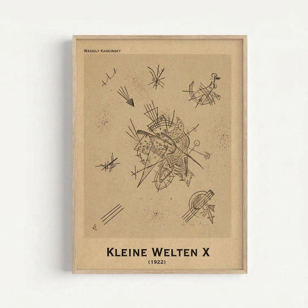 Framed abstract artwork by Wassily Kandinsky featuring black line drawings on beige paper background. The composition shows geometric shapes, radiating lines, dots, and angular forms scattered across the surface. Central cluster of intersecting lines and curves dominates the middle, with smaller abstract elements positioned around the edges. Thin wooden frame with natural finish against white wall. Minimalist presentation showcasing the artist's characteristic abstract expressionist style with p