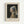 May include: Framed reproduction of Vermeer's Girl with a Pearl Earring displayed on white wall. Light wood frame surrounds cream matted print showing young woman in blue and yellow turban with pearl earring against dark background. Title text below image reads "Johannes Vermeer Girl with a Pearl Earring" in serif font.