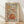 May include: Framed poster with wooden frame leaning against white wall on light wood floor. Features colorful retro-style illustration of potted plant with flowing vines, flowers, and mushrooms in earthy orange, green, purple, and yellow tones. Text reads "Less Attitude More Gratitude" in bold black letters at top and bottom. Artwork has vintage botanical folk art aesthetic on cream background.