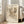 May include: Abstract art print by Wassily Kandinsky in light wood frame, leaning against white wall next to beige sofa. The artwork features dynamic black ink drawings with geometric shapes, organic forms, and intersecting lines on cream background. Bright natural light streams through tall windows onto hardwood floors in minimalist living room setting.