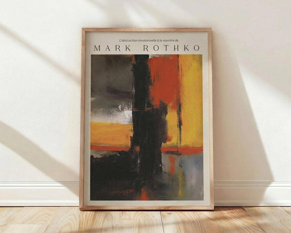 May include: Framed abstract art poster leaning against white wall on light wood floor. Features bold blocks of orange, red, yellow, black and gray paint in expressionist style. Natural wood frame with white matting. Soft window light creates shadows on textured wall surface.