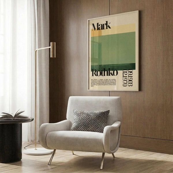 May include: Modern minimalist artwork displayed in contemporary living room setting featuring beige armchair with geometric pillow, brass floor lamp, and dark wood wall paneling. The framed poster shows abstract color blocks in green, yellow and cream tones with "Mark Rothko" text and dates. Styled with side table holding open book and white curtains visible in background.