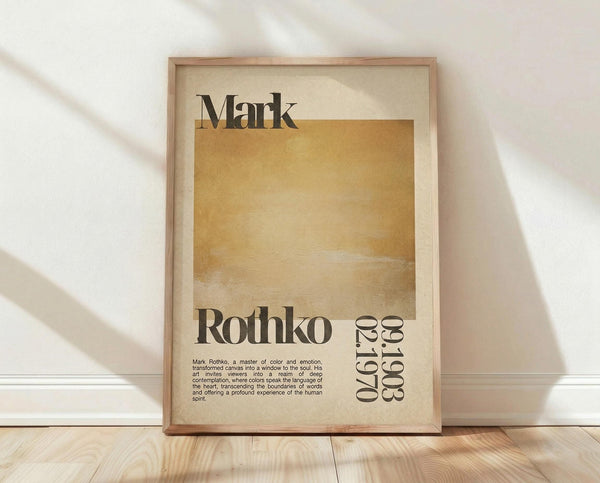 May include: A framed poster with Mark Rothko's name in bold black letters at the top, featuring a large golden-yellow abstract color block in the center, with "Rothko" and "02.1970" text below, plus a small paragraph of descriptive text. The cream and tan colored print is displayed in a light wood frame, leaning against a white textured wall on wooden flooring with natural sunlight casting diagonal shadows across the scene.