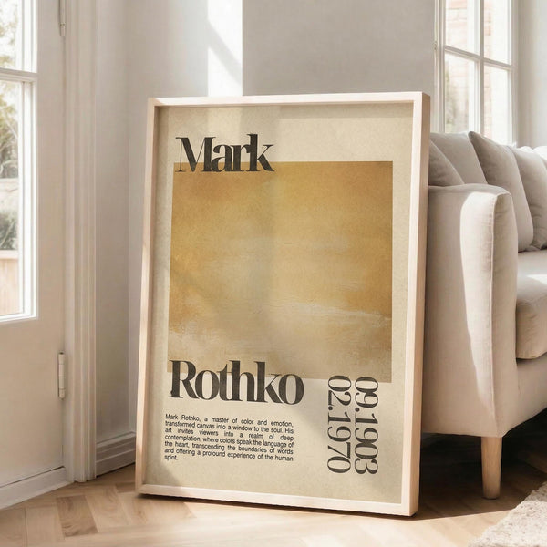 May include: Framed vintage-style poster with cream and golden yellow watercolor background, featuring "Mark Rothko" in bold black text and dates "02.1970" and "1903-1970" vertically aligned. Small paragraph of biographical text in bottom left corner. Light wooden frame leaning against white wall next to beige sofa with throw pillows in bright, naturally lit room with large windows.