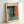 May include: Framed abstract art print in light wood frame leaning against white wall. The artwork features soft, blended colors including teal blue, orange-red, sage green, and cream in Rothko's characteristic color field style. French text at top reads "L'abstraction émotionnelle à la manière de" followed by "MARK ROTHKO" in capital letters. Natural lighting creates subtle shadows on the minimalist white surface.