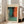 May include: Large framed abstract art print leaning against white wall in bright living room with beige sofa. Artwork features bold color blocks in turquoise, orange, and dark tones with soft blended edges in Rothko's signature style. Light wood frame with cream matting. Sunlight streams through tall windows onto hardwood floors.