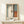 May include: Framed abstract art print in light wood frame leaning against white wall on light wooden surface. Artwork features soft blocks of blue, white, coral orange, and dark vertical stripe in Rothko's color field style. Small wrapped gift box with evergreen sprig sits in front of frame. Minimalist modern interior setting with natural lighting and clean aesthetic.