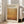 May include: Framed art poster with cream background featuring large amber-orange gradient rectangle and black text reading "MARK ROTHKO" and "Rothko Art Gallery, New York City" with exhibition details. Poster leans against white wall beside beige sofa in bright, sunlit living room with hardwood floors.