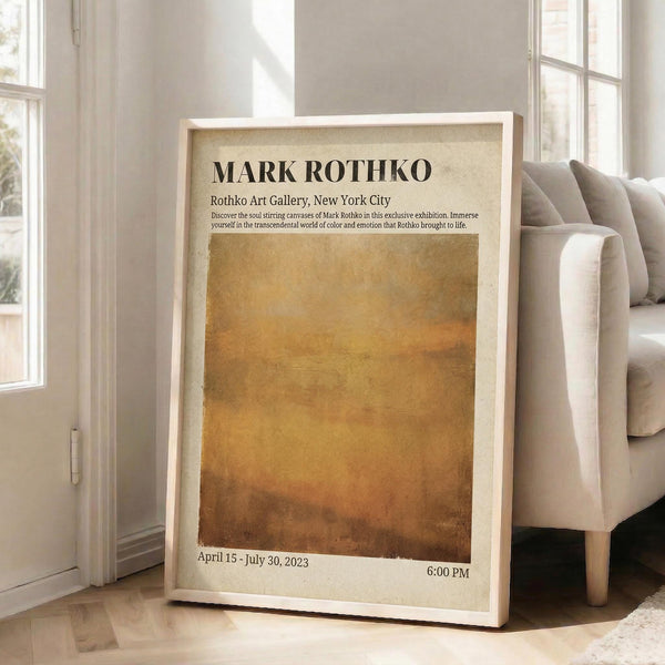 May include: Framed art poster with cream background featuring large amber-orange gradient rectangle and black text reading "MARK ROTHKO" and "Rothko Art Gallery, New York City" with exhibition details. Poster leans against white wall beside beige sofa in bright, sunlit living room with hardwood floors.