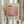 May include: Person in cream sweater holding framed poster featuring orange and purple gradient watercolor design with "Mark Rothko" text and biographical description. Light wooden frame against neutral curtained background with dried pampas grass visible to left side.
