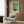 a modern living room with a white armchair, a floor lamp, and a framed abstract painting on the wall.